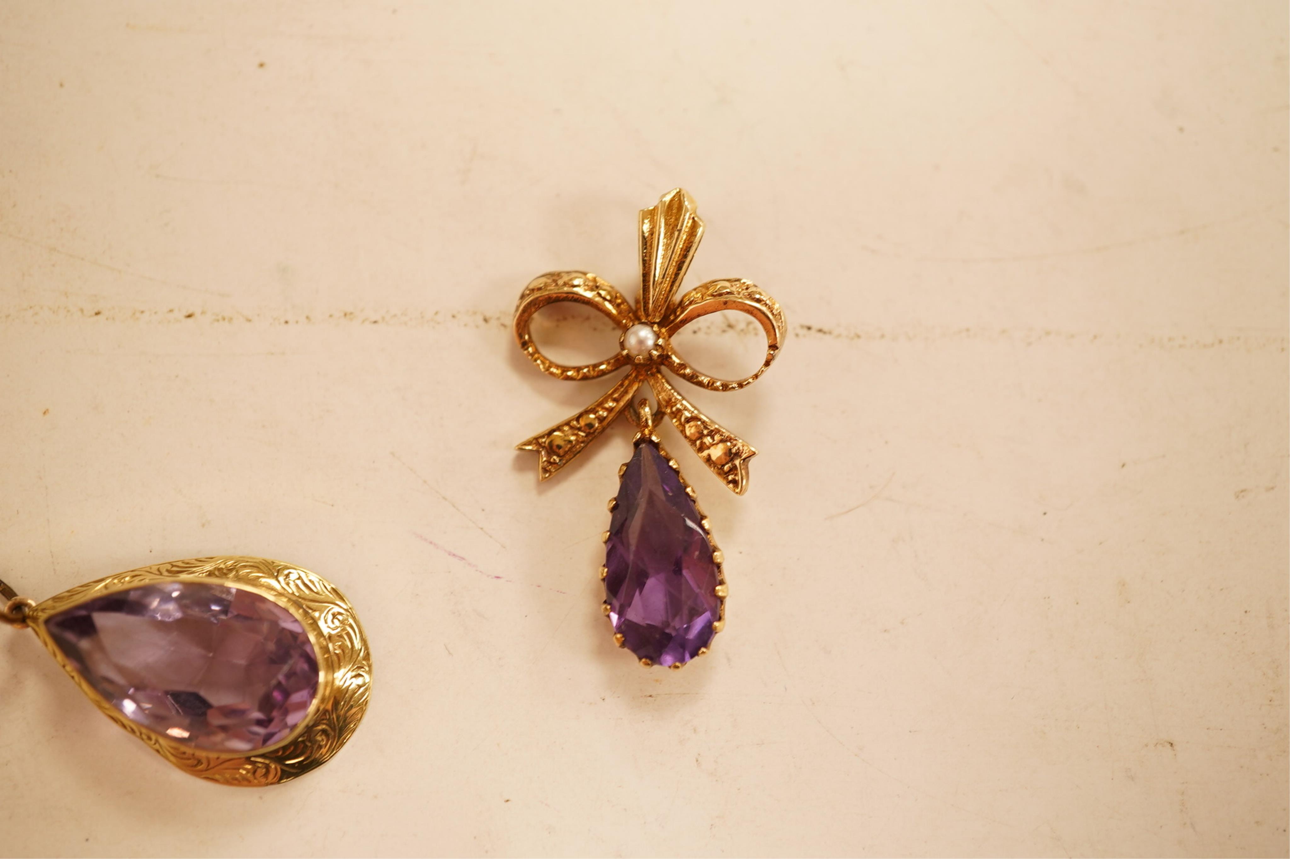 A 1970's 9ct gold, amethyst and seed pearl set drop pendant, 29mm, together with a yellow meta and amethyst set drop pendant.